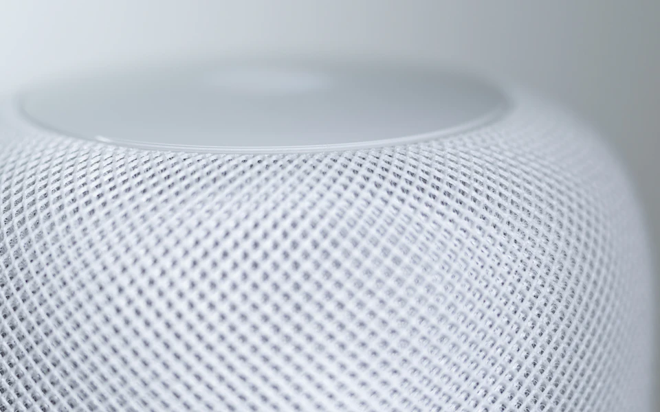 Close-up of a white fabric-covered smart speaker; illustrative category photo.